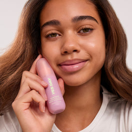 YES DAY founder Coco holding Inner Beam Hydration Mist and smiling.